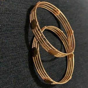 Gold tone bangles with Victorian logo